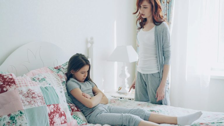 Madre e hija adolescente discutiendo en el dormitorio